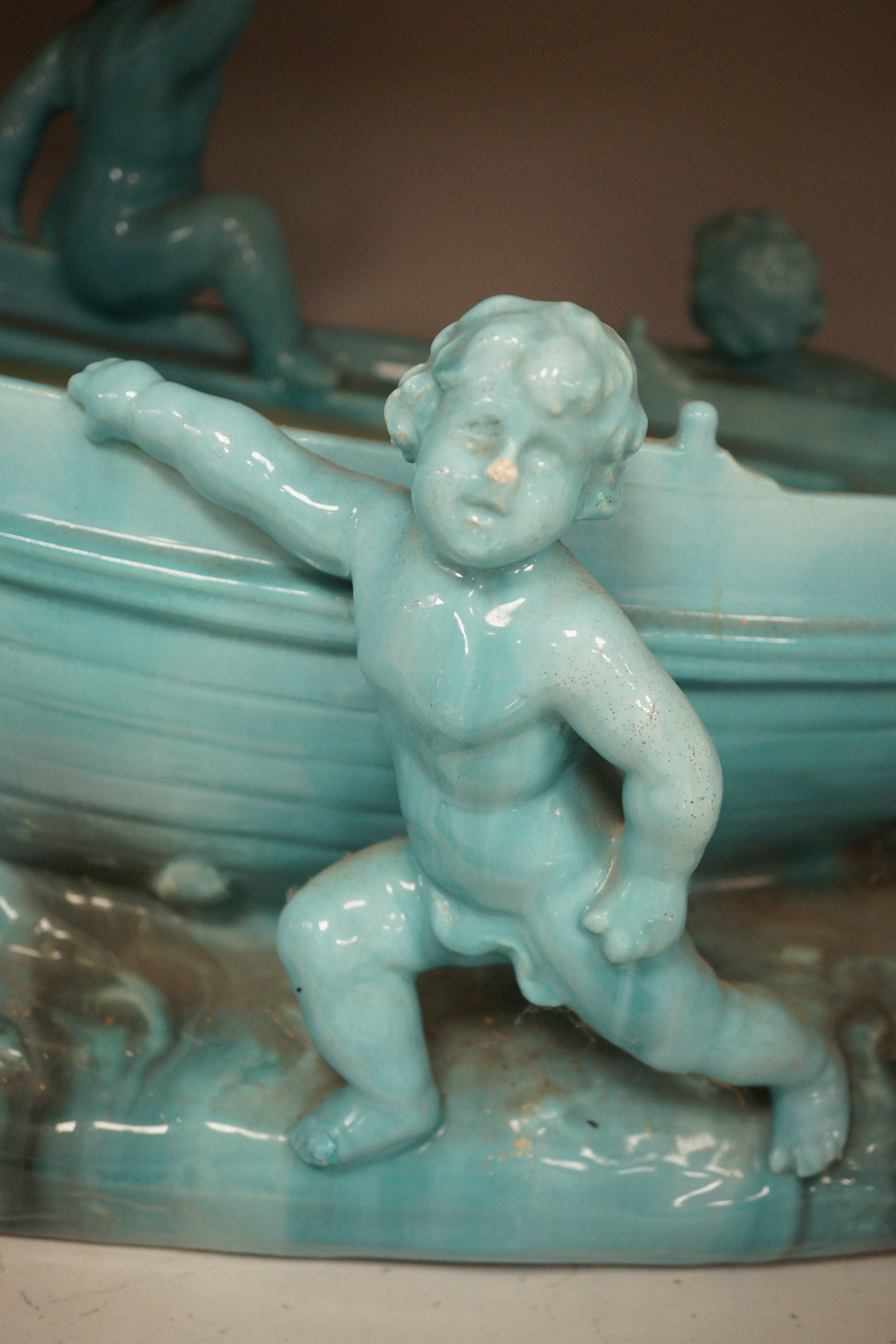 A large Continental majolica centrepiece with cherub figures and boat, 56cm